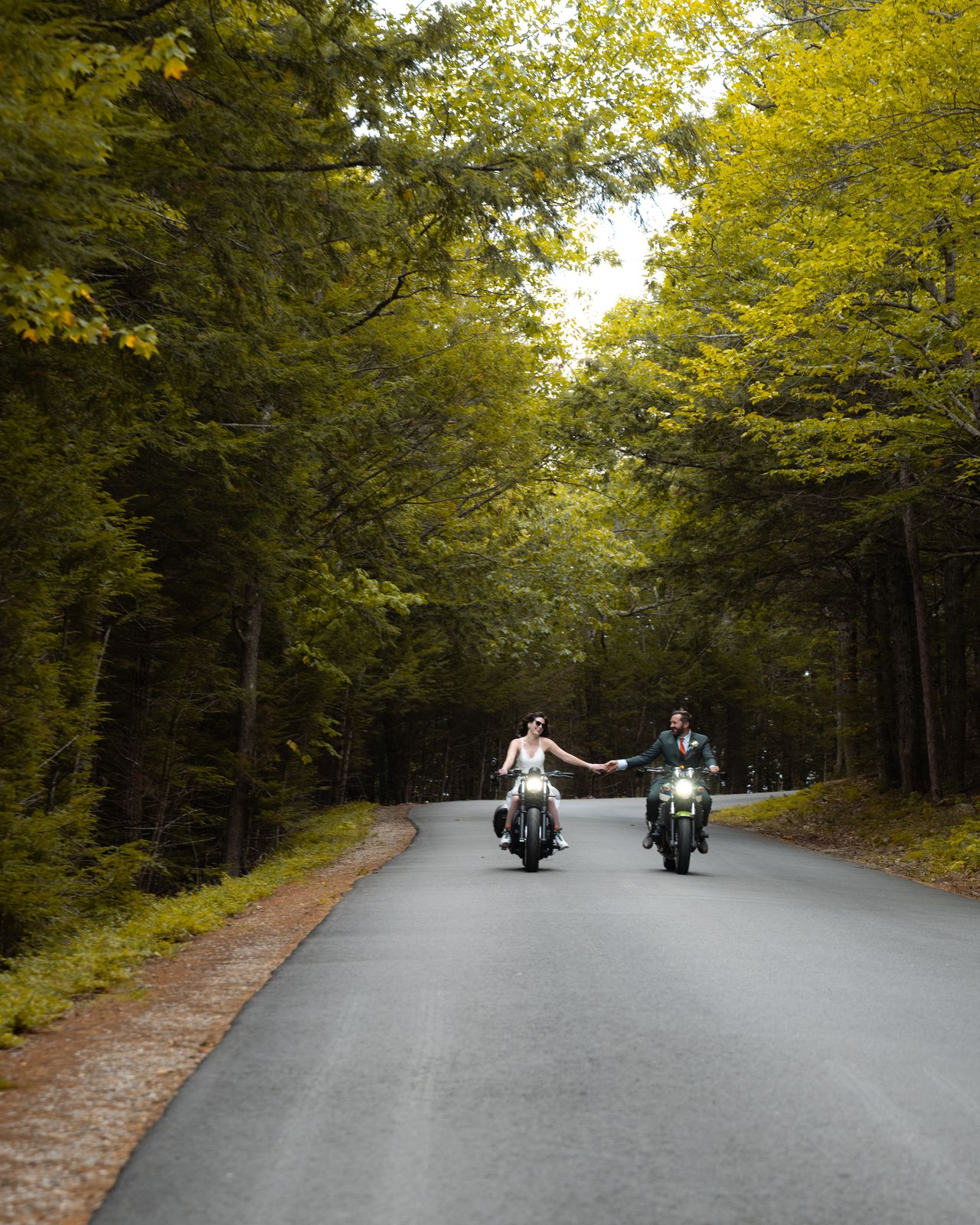 Bride and groom riding motorcycles up the Cathedral Ledge road on their wedding day