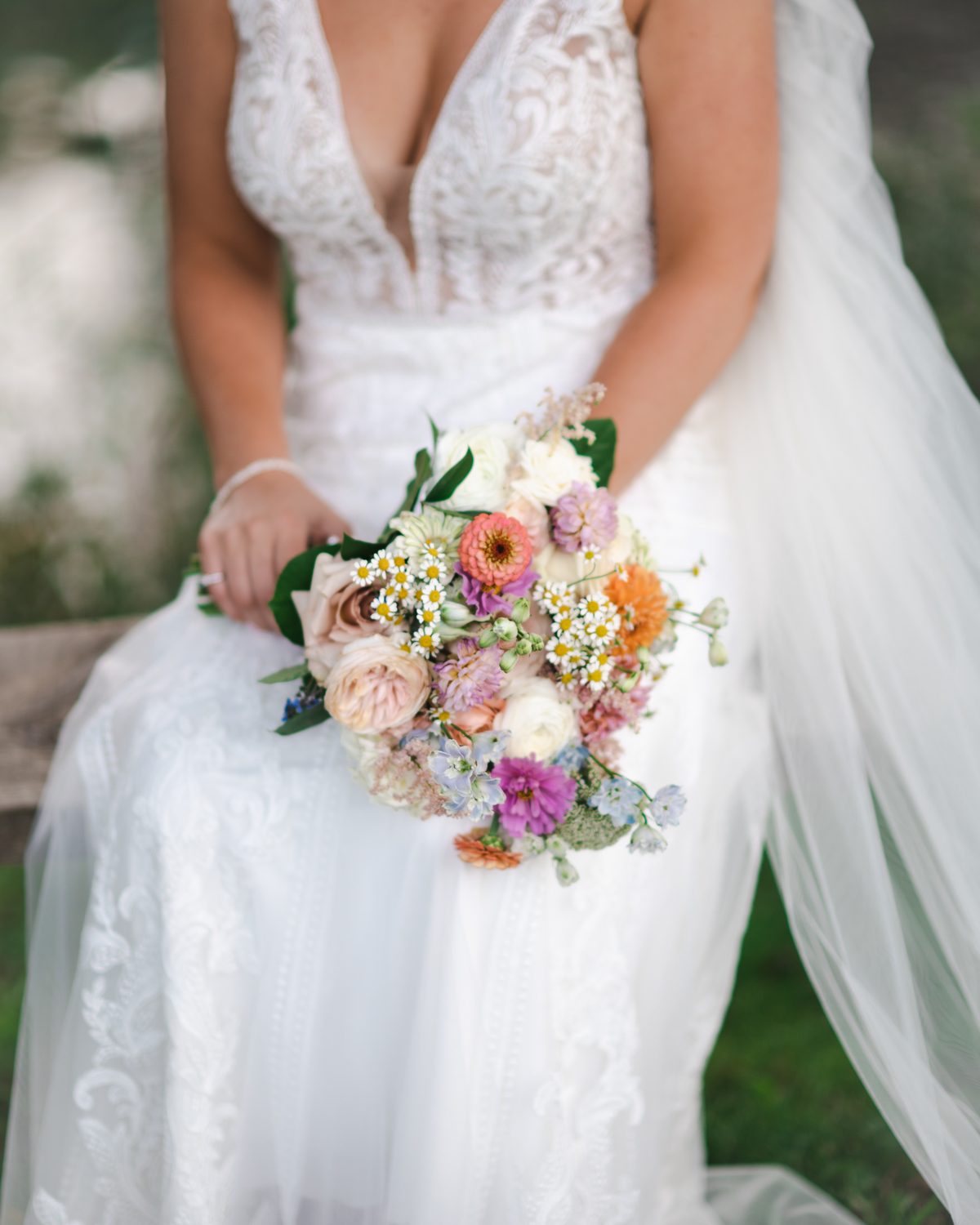 Bride holding a colorful wildflower bouquet in her gown