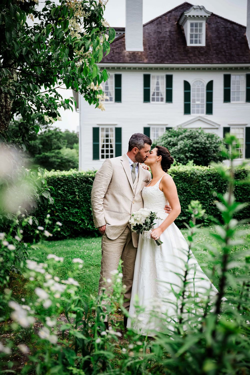 Bride and groom kissing in a New Hampshire estate garden